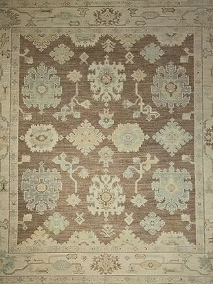 A brown and white rug with a floral pattern on it.