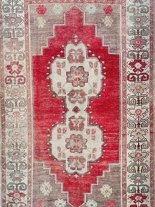 A red and white rug with a floral pattern on it.