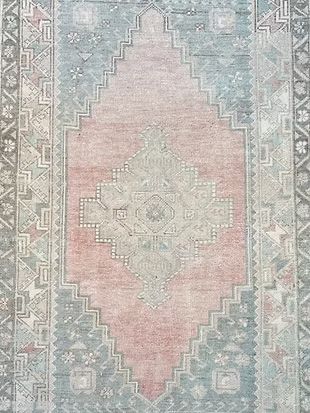 A close up of a pink and blue rug with a pattern on it.