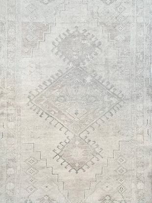 A close up of a white rug with a geometric pattern on it.