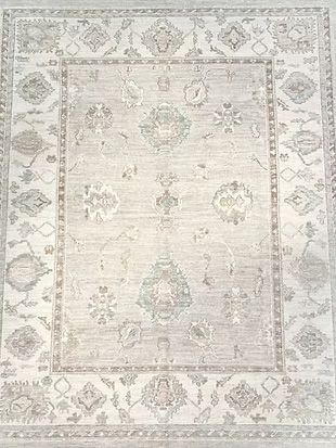 A white rug with a floral pattern on it is sitting on a table.