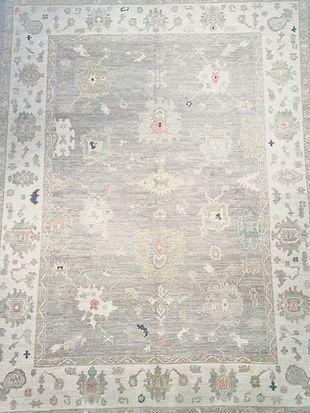 A large rug with a floral pattern on it is sitting on a table.