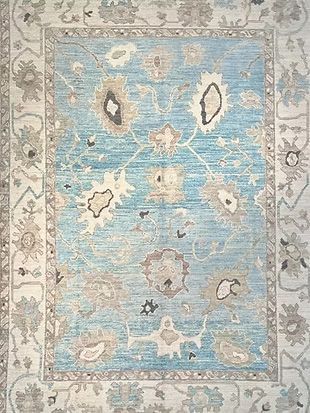 A blue and white rug with a floral pattern on it.