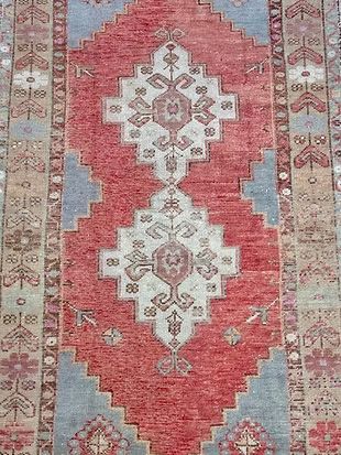 A close up of a red and blue rug with a pattern on it.