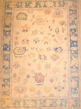 A rug with a floral pattern and a blue border is sitting on a table.