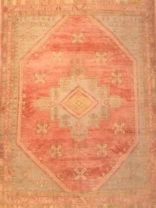A close up of a pink rug with a diamond pattern on it.