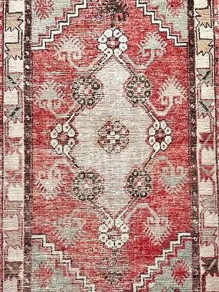 A red and white rug with a geometric pattern on it.