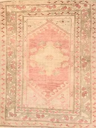 A pink and white rug with a floral pattern on it.
