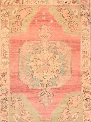 A pink and green rug with a floral pattern on it.