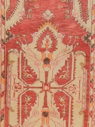 A close up of a rug with a red and white pattern