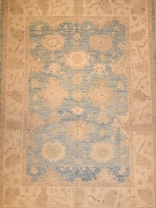 A blue and white rug with flowers on it is sitting on a table.