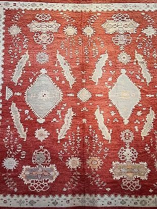 A red rug with white patterns on it is sitting on a table.