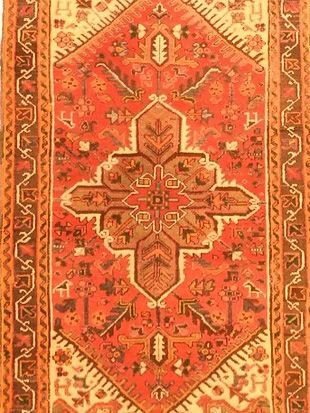 A close up of a red rug with a pattern on it.