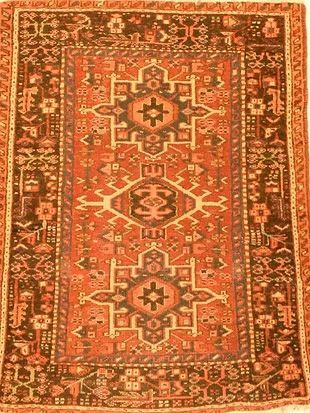 A rug with a geometric pattern on it is hanging on a wall.