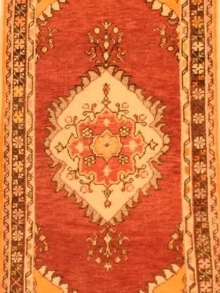 A red and yellow rug with a floral pattern on it