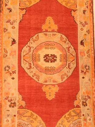 A red and yellow rug with a circular design on it
