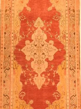 A red and yellow rug with a floral pattern on it