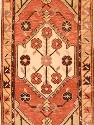 A rug with a geometric pattern and flowers on it