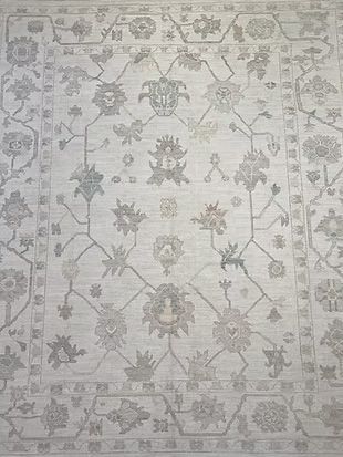 A white rug with a floral pattern on it is sitting on a table.