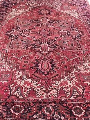 A close up of a red rug with a pattern on it.