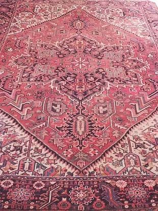 A close up of a red rug with a pattern on it.