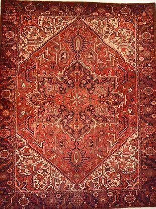 A red rug with a diamond pattern on it is sitting on a white surface.