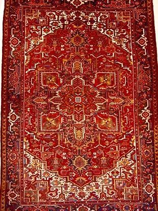 A red rug with a pattern on it is on a white background.
