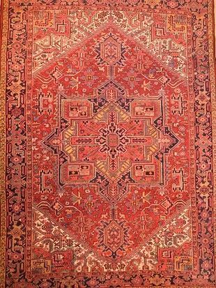 A close up of a red rug with a pattern on it.