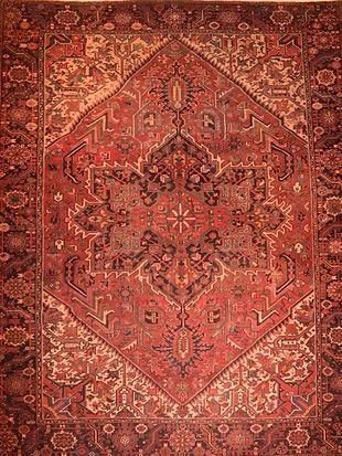 A close up of a red rug with a diamond pattern on it.
