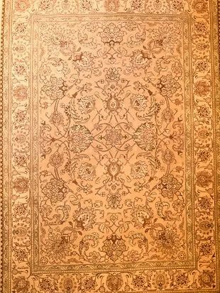 A rug with a floral pattern on it is on a wall.