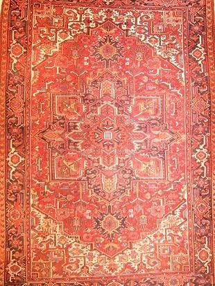 A close up of a red rug with a pattern on it.
