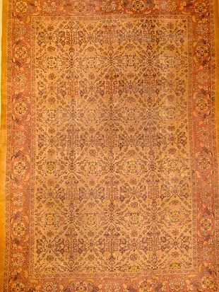 A large rug with a floral pattern on it is hanging on a wall.