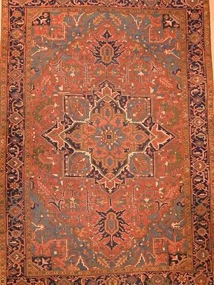 A rug with a pattern on it is hanging on a wall.