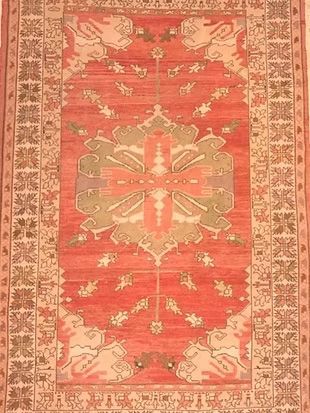 A red rug with a pattern on it is sitting on a table.