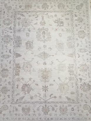 A white rug with a floral pattern on it is sitting on a table.