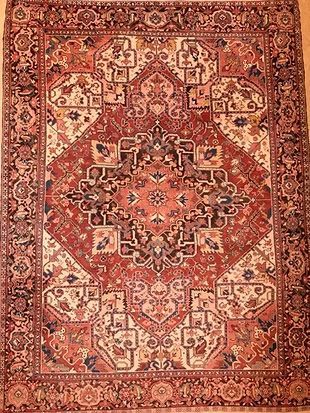 A rug with a pattern on it is hanging on a wall.