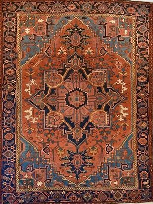 A rug with a floral pattern on it is hanging on a wall.