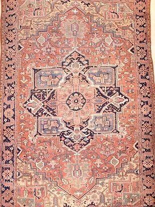 A rug with a pattern on it is hanging on a wall.