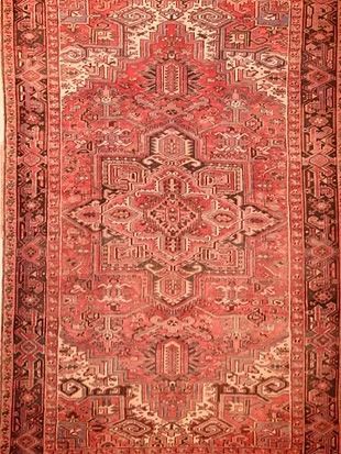 A close up of a red rug with a pattern on it.