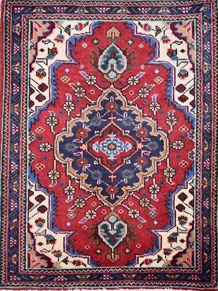A red and blue rug with a floral pattern on it