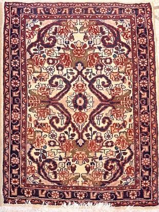 A rug with a floral pattern on it is hanging on a wall.