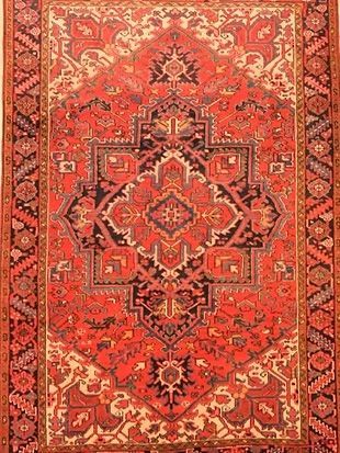 A red rug with a pattern on it is sitting on a table.