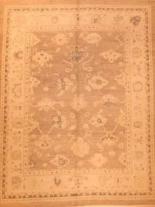 A rug with a floral pattern on it is sitting on a wooden floor.