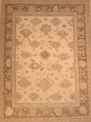 A rug with a floral pattern and a brown border