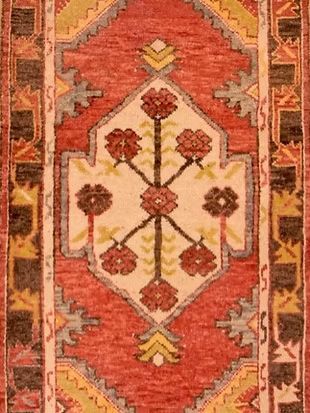 A rug with a geometric pattern and flowers on it