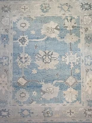 A blue and white rug with a floral pattern on it.