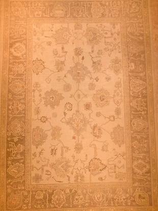 A rug with a floral pattern on it is sitting on a wooden floor.