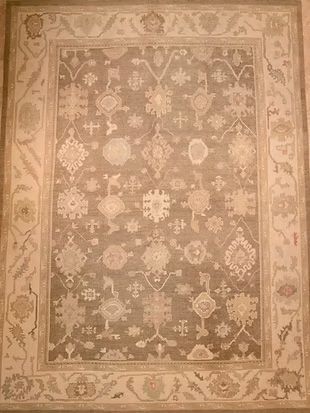 A rug with a floral pattern on it is on a wall.