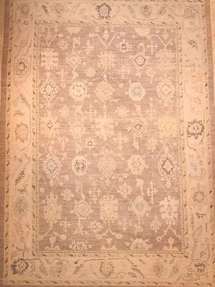 A rug with a floral pattern on it is sitting on a wooden floor.