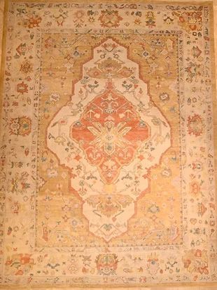 A rug with a floral pattern on it is hanging on a wall.